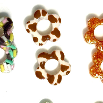 Colorful flower-shaped hair ties on a white background